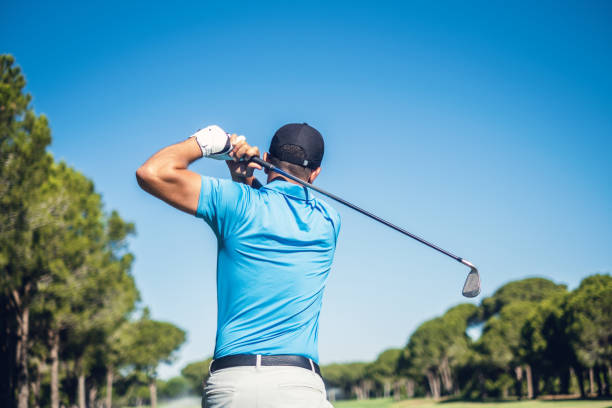 Golf Player Male golf player swinging golf club. swinging stock pictures, royalty-free photos & images