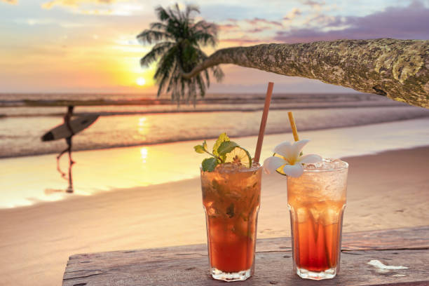 drinks with blur tropical beach and sunset in background drinks with blur tropical beach and sunset in background beach goa party stock pictures, royalty-free photos & images