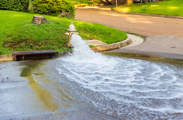 Open fire hydrant gushing water onto street. Water flowing from open Fire Hydrant flushing water stock pictures, royalty-free photos & images