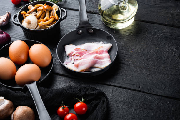 istock Breakfast egg ingredients, on black wooden table background, top view flat lay , with space for text  copyspace 1329921705