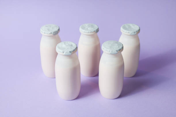 istock Bottles with probiotics and prebiotics dairy drink on light purple background. 1329921830