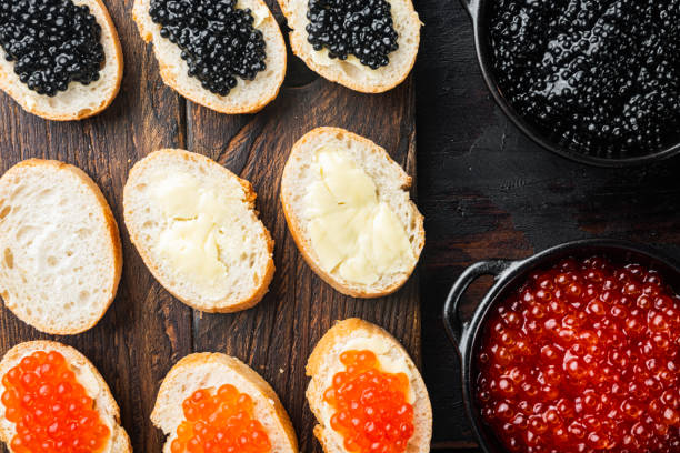 Canapes with black sturgeon and salmon fish caviar, on old dark  wooden table background, top view flat lay Canapes with black sturgeon, and salmon fish caviar, on old dark  wooden table background, top view flat lay trout lake stock pictures, royalty-free photos & images