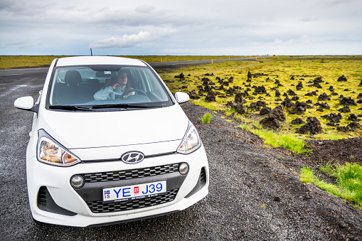 Vik, Iceland - June 14, 2018: Small white Hyundai i10 smart car parked in parking lot by ring road in Laufscalavarda, South Iceland desolate barren scenery