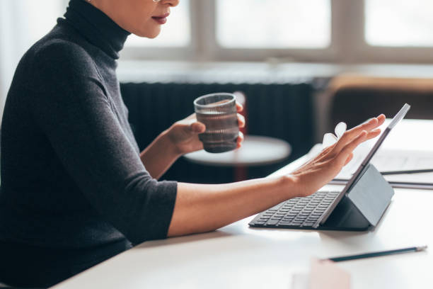 Unrecognizable Female Architect Holding a Glass of Water while Working in her Studio