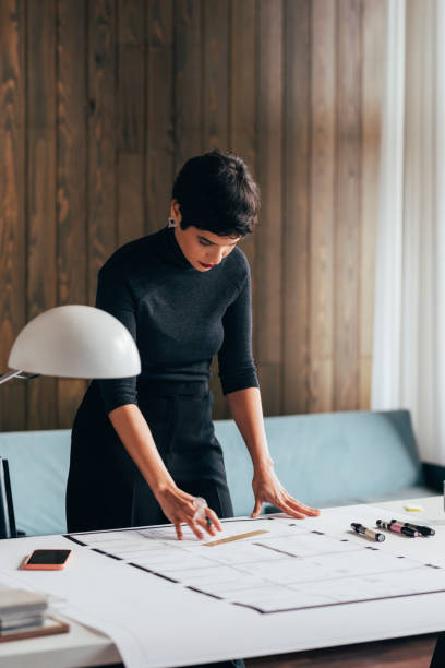 istock Devoted Female Architect Working on an Architectural Drawing of a Building 1329929720