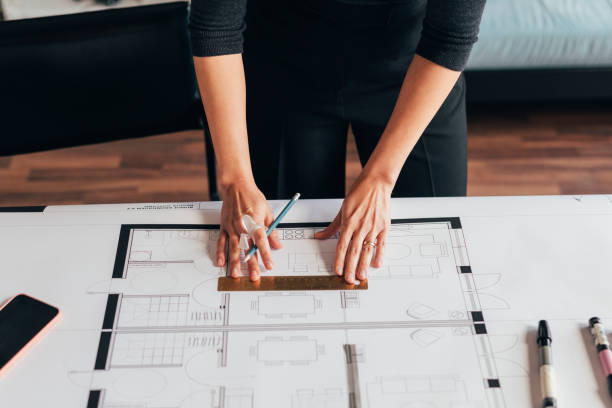 istock Anonymous Female Architect Working on an Architectural Drawing of a Building 1329929722