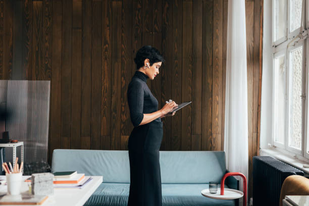 istock Beautiful Young Female Designer Standing in her Office and Working, Using a Digital Tablet 1329929731