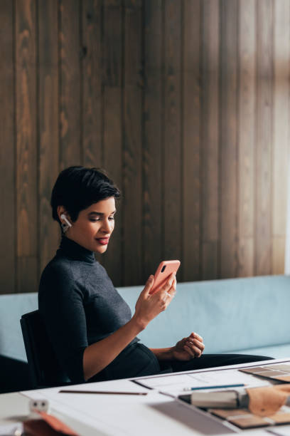 istock Beautiful Young Woman Using her Smartphone at Work 1329929735