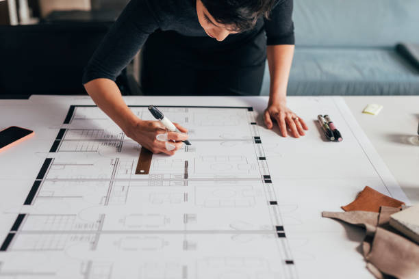 istock Anonymous Female Architect Working on an Architectural Drawing of a Building 1329929739