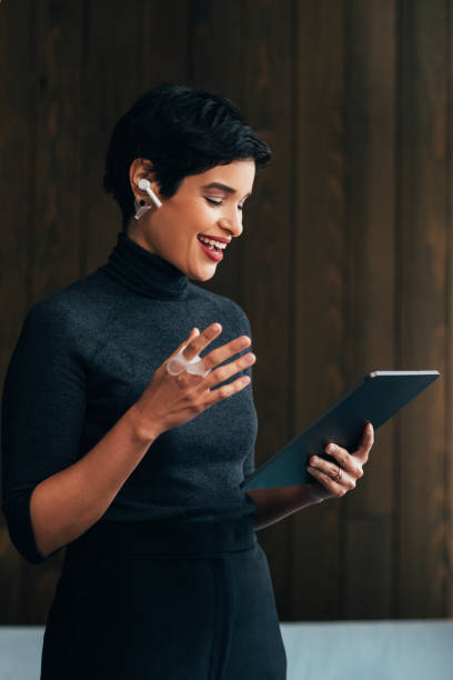 istock Smiling Young Female Architect Joining a Video Call via her Digital Tablet 1329929753