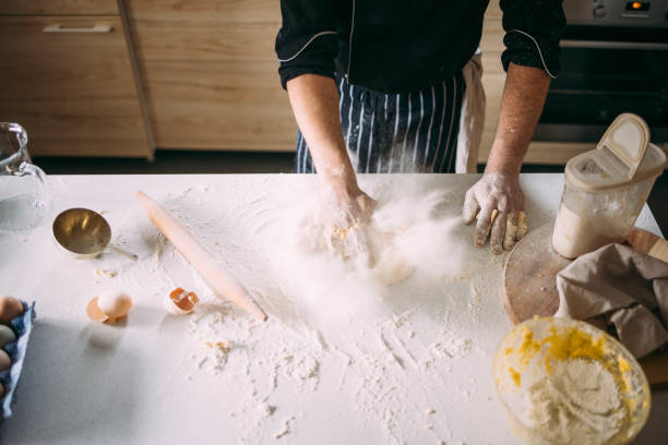 istock Overhead Shot of an Anonymous Professional Chef Punching Dough while Kneading it 1329929971