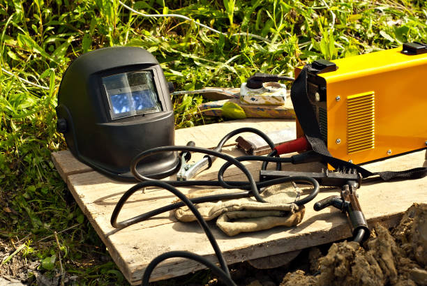 istock Welding machine and protective helmet. Tools for electric welding close up. 1329930718