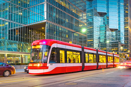 Streetcar stands at a stop light in downtown Toronto Ontario Canada in the evening.