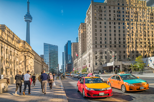 People and cars move past Union Station in downtown Toronto Ontario Canada on a sunny day.