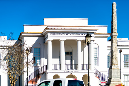 Walterboro, USA - February 3, 2021: Colleton county courthouse building with sign at white architecture facade and column art in South Carolina