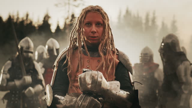 Epic Battlefield: Portrait of Powerful Female Leader Warrior Holding Sword, Ready for Battle. Woman Knight General in Dark Age Medieval War against Invasion. Dramatic, Cinematic, Historic Reenactment