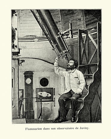 Vintage photograph of Camille Flammarion, French astronomer, looking through telescope at Observatory at Juvisy-sur-Orge, 1890s