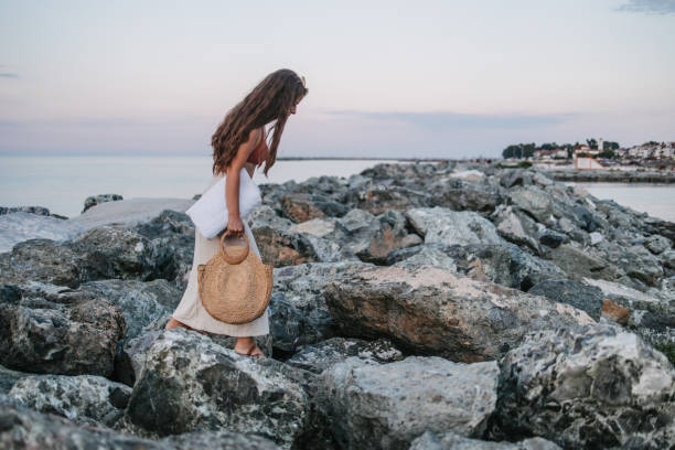 A young woman walking over the rocks returning from the beach