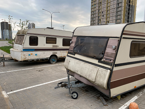 Old white rusty caravan trailers, mobile homes are parked