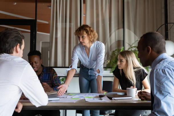 istock Confident businesswoman mentor explaining strategy, leading briefing with diverse employees 1329936169