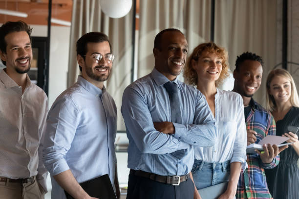 istock Dreamy smiling diverse employees colleagues team looking to aside 1329936173