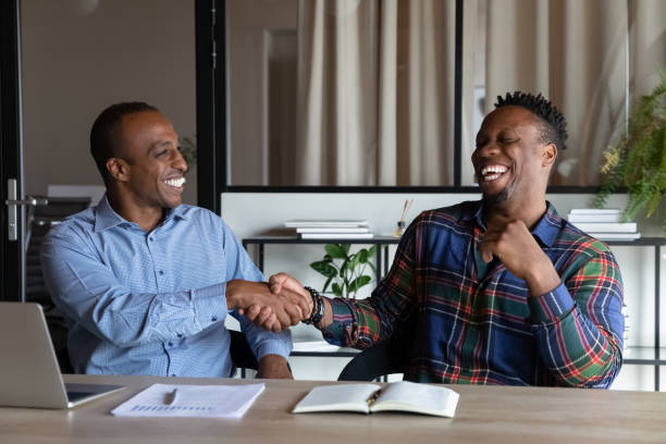 overjoyed african american business partners shaking hands at meeting - human resources interview talking people imagens e fotografias de stock