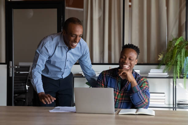 istock Excited African American colleagues working on project together, using laptop 1329936197