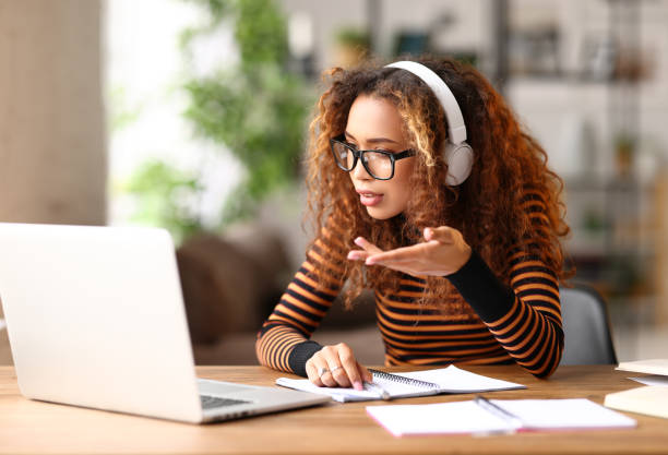 istock Focused afro american female having video call while working remotely or studying online on laptop from home 1329936522