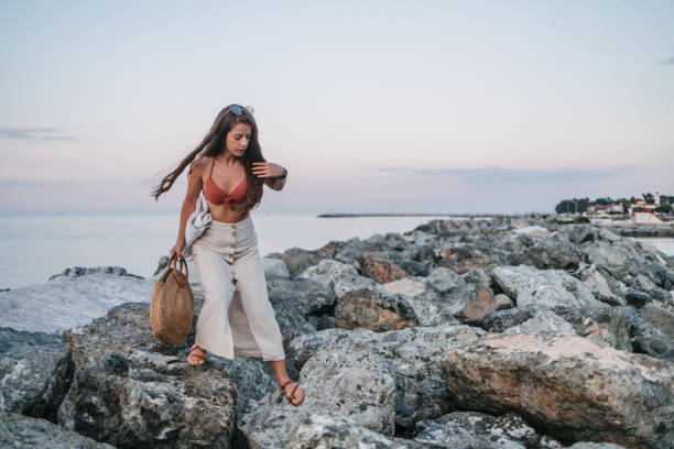 A young woman walking over the rocks returning from the beach
