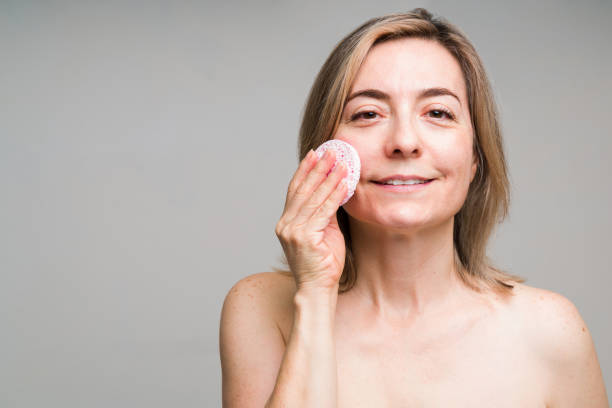istock Older woman removing dead cells from her skin 1329938058