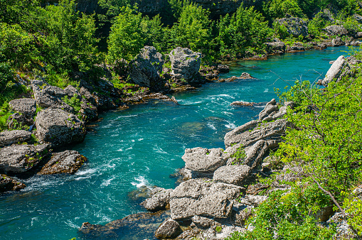 Beautiful landscape - turquoise bright lake Ritsa among green hills with forests and clear blue sky on a summer day in Abkhazia and a space to copy