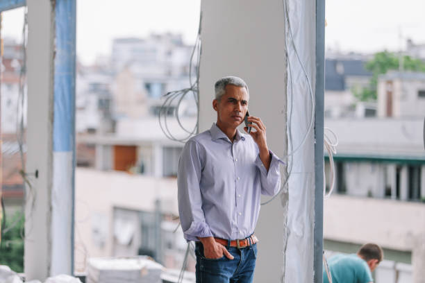 istock Male investor on the phone while inspecting the construction site 1329945188