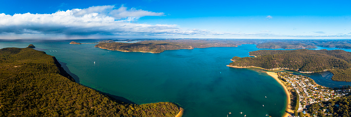 Aerial panoramic view of the Hawkesbury river from the Central Coast, looking towards Sydney, West Head, with Patonga to the right, and a storm with clouds to the left.