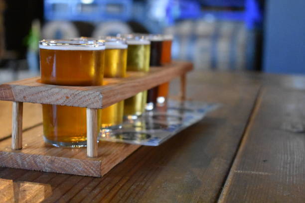 istock Beer flights samples in wood serving tray on pub table. 1329946857