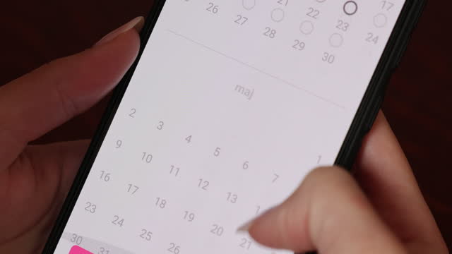 Close up of woman's hand using a smartphone calendar application
