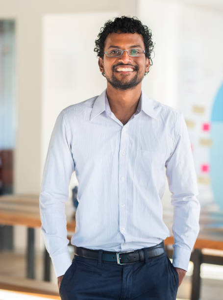 istock Young business man smiling while standing in a modern office 1329949253