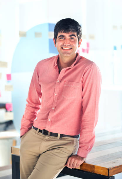 istock Smiling business man leaning on a table in an office 1329949257
