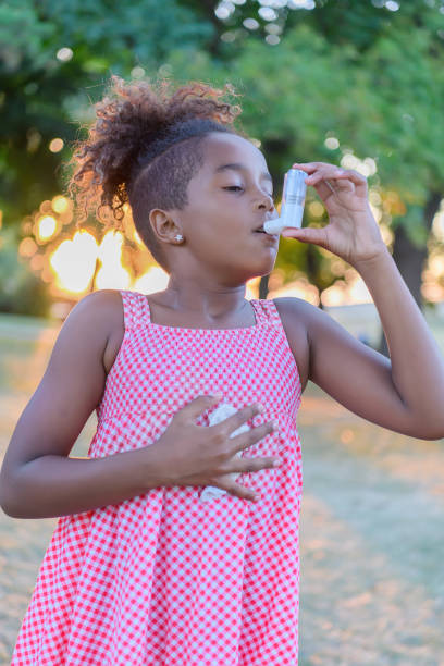 istock Beautiful Little African-American Girl is Having Asthmatic Problems Outside in Nature. 1329950123