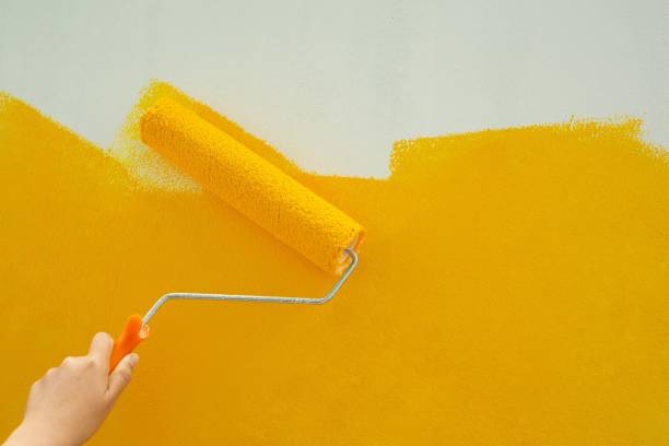 istock Use a roller to paint yellow manually. beautiful and economical 1329967543