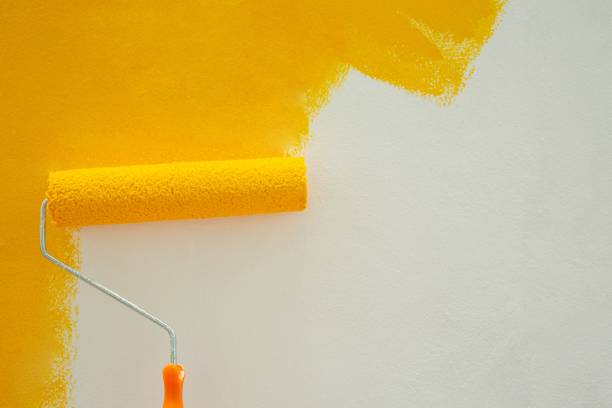 istock Paint yellow with a roller on the wall DIY by yourself 1329967547