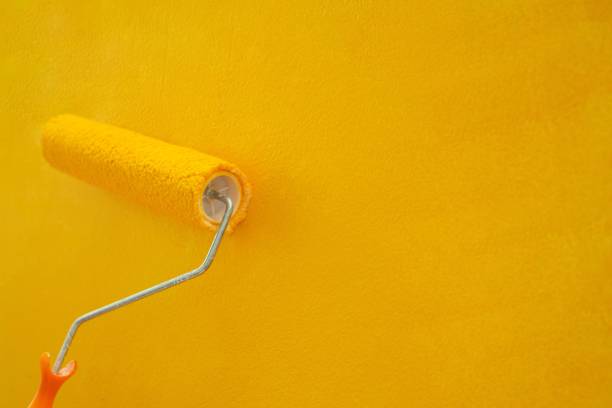 istock Use a roller to correct, improve, decorate, paint yellow manually. beautiful and economical 1329967553