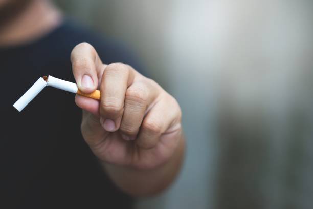 A man is trying to quit smoking for himself, his family and society. stock photo