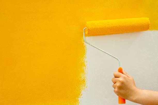 istock Use a roller to manually paint the yellow bedroom walls. 1329967579
