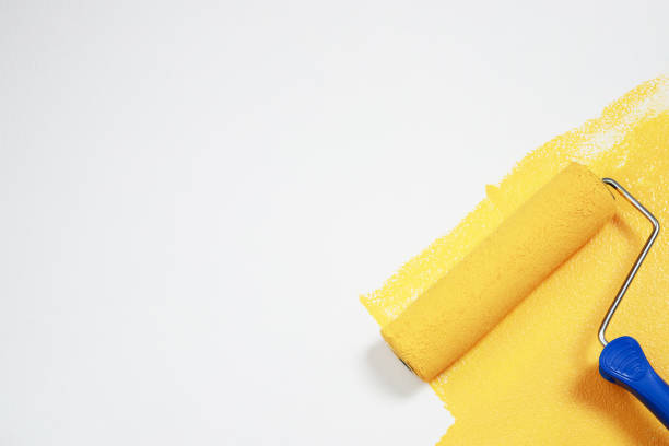 istock Painter is painting the interior wall yellow 1329974318