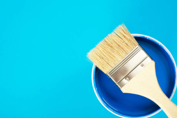 istock A paint brush is placed on a paint can. with blue background 1329974333