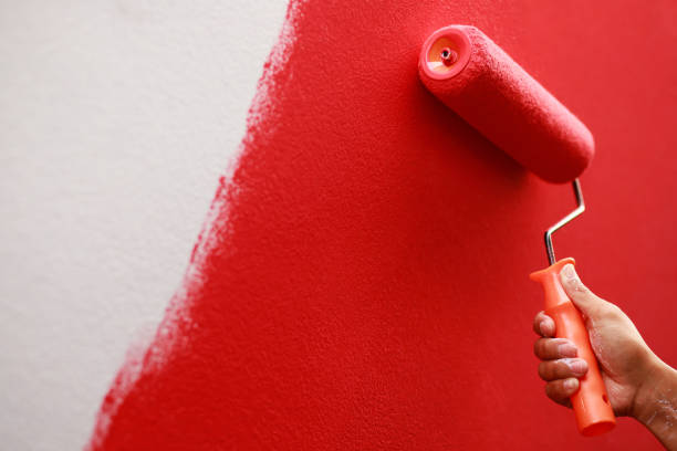istock Painter is painting the interior wall red 1329974340