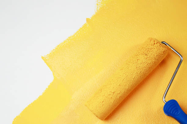 istock Painter is painting the interior wall yellow 1329974354