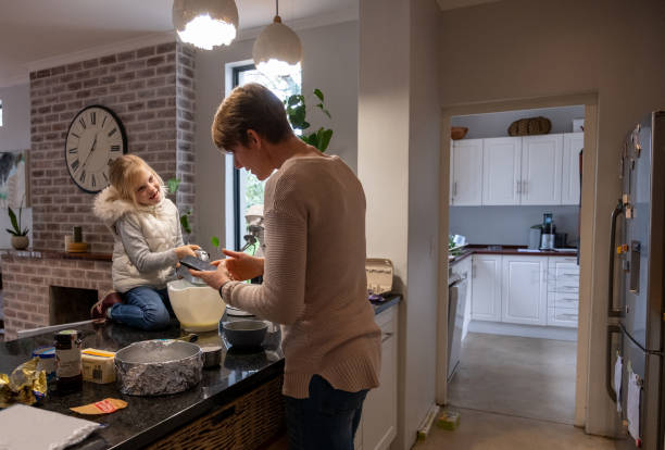 istock Girl helps her mom bake a cake 1329982628