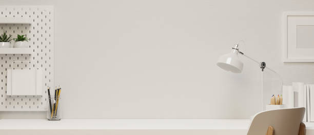 istock Modern home working space with copy space and frame mock-up in white tone interior 1329984996