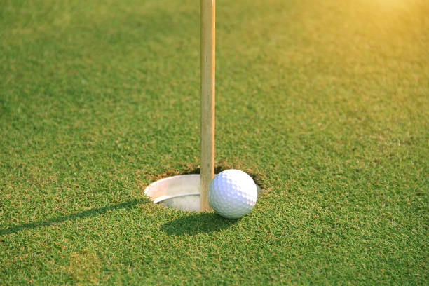 istock Golf ball on green in the evening golf course 1329986831